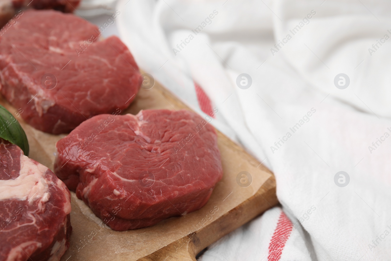 Photo of Cut fresh beef meat on wooden board, closeup. Space for text