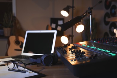 Photo of Professional audio equipment on table in modern radio studio