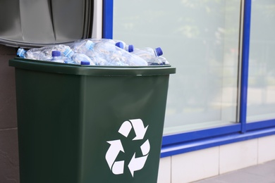 Many used plastic bottles in trash bin outdoors. Recycling problem