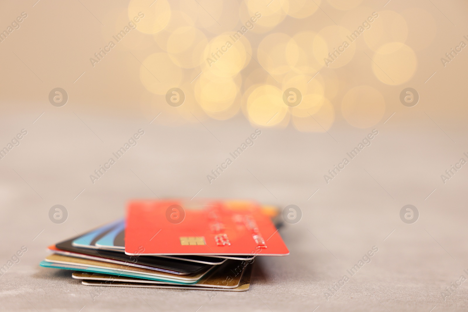 Photo of Pile of different credit cards on grey table, closeup. Space for text