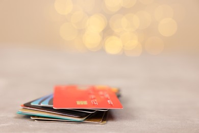 Photo of Pile of different credit cards on grey table, closeup. Space for text