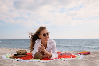 Photo of Beautiful woman lying on beach towel near sea