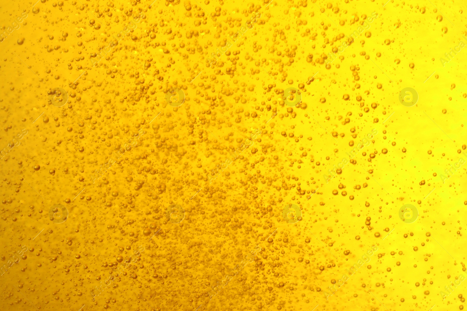 Photo of Tasty beer with bubbles as background, closeup