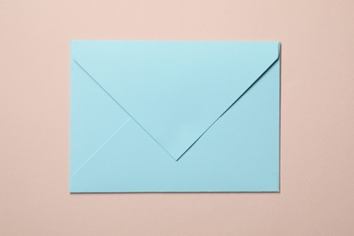 Photo of Letter envelope on beige background, top view