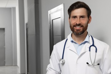 Photo of Doctor in white coat with stethoscope indoors. Space for text