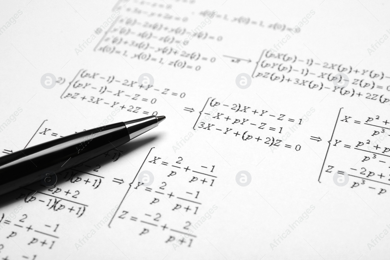 Photo of Sheet of paper with mathematical formulas and pen, closeup