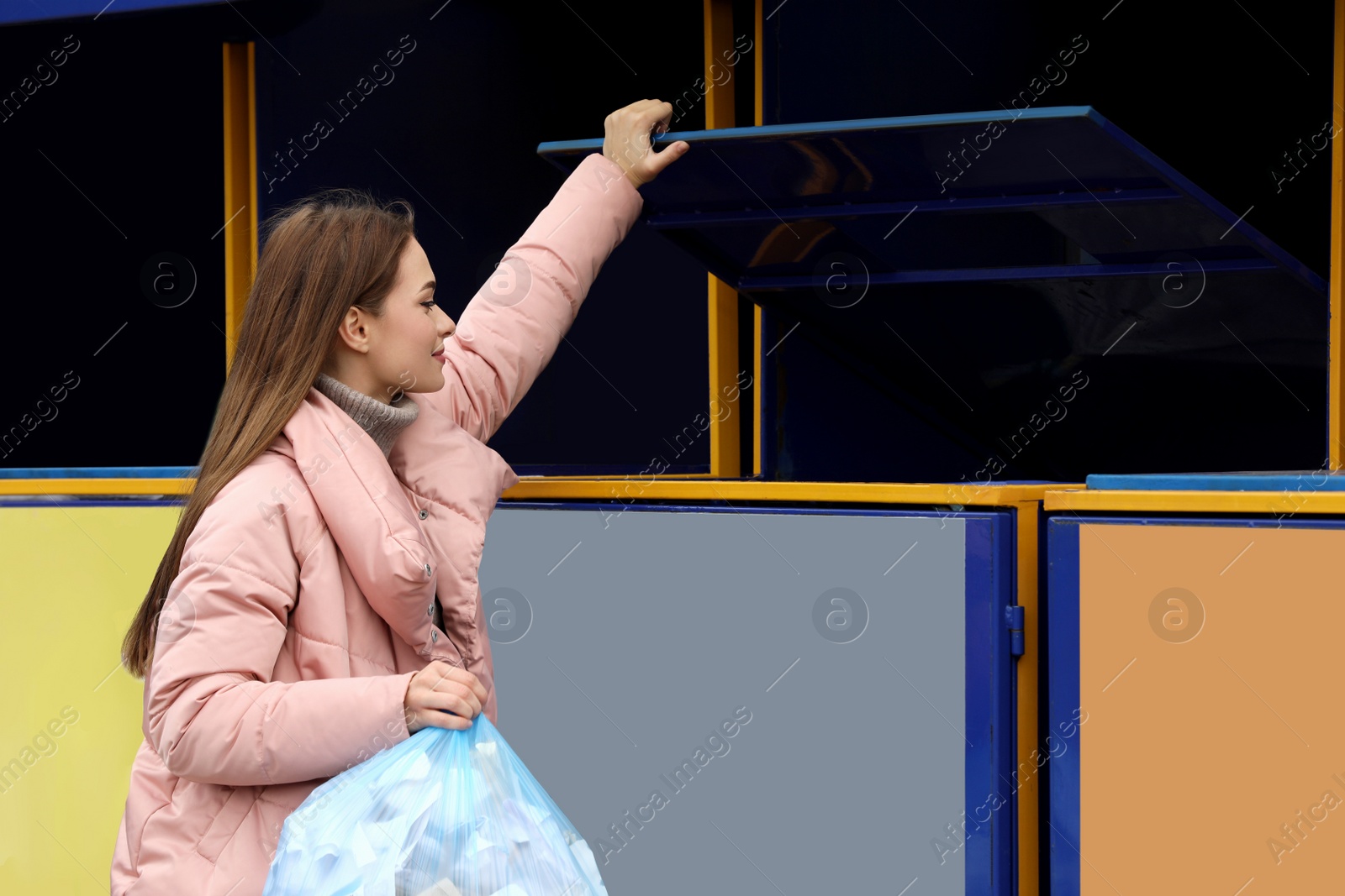 Photo of Woman throwing garbage into bin at recycling point outdoors