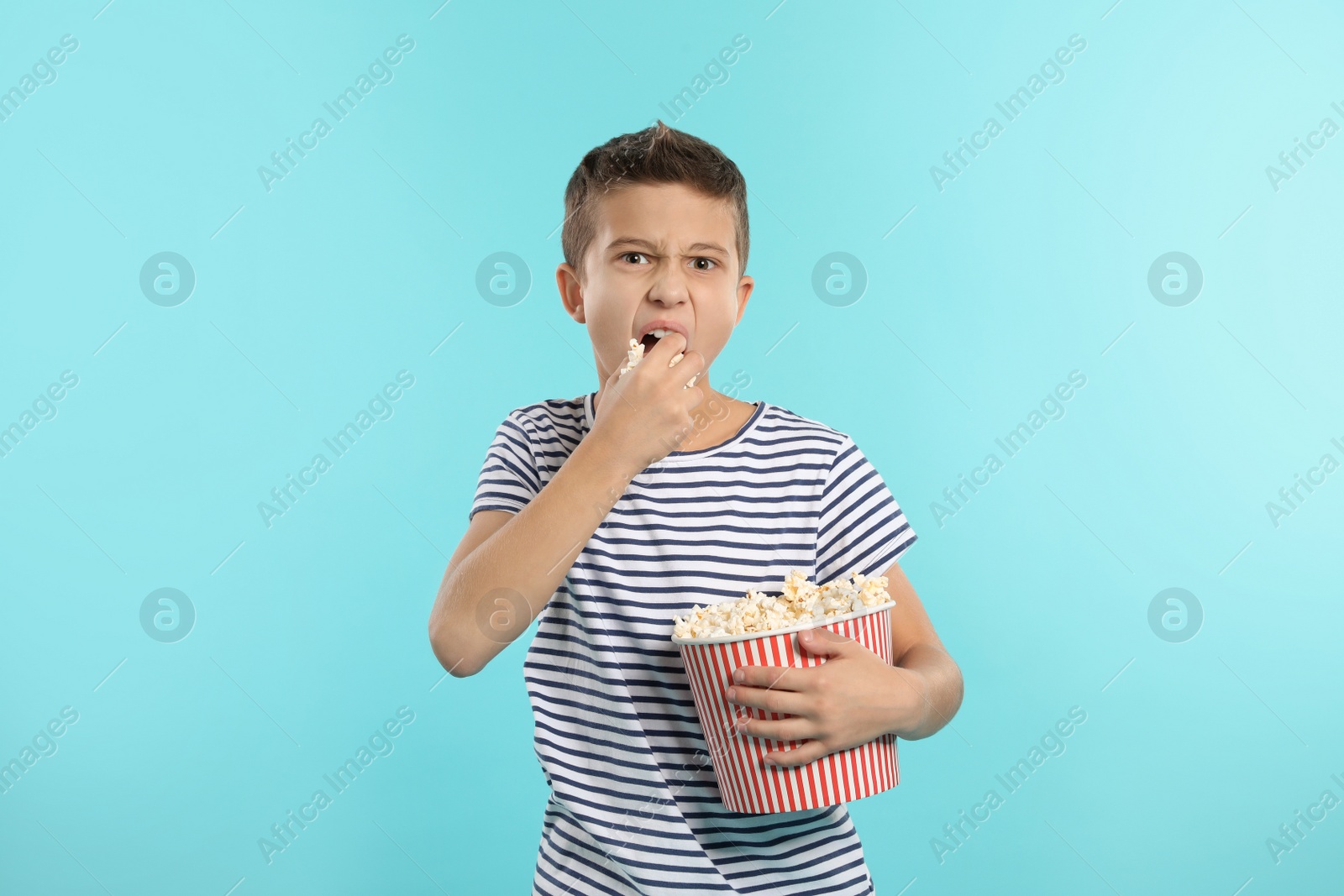 Photo of Boy with popcorn during cinema show on color background