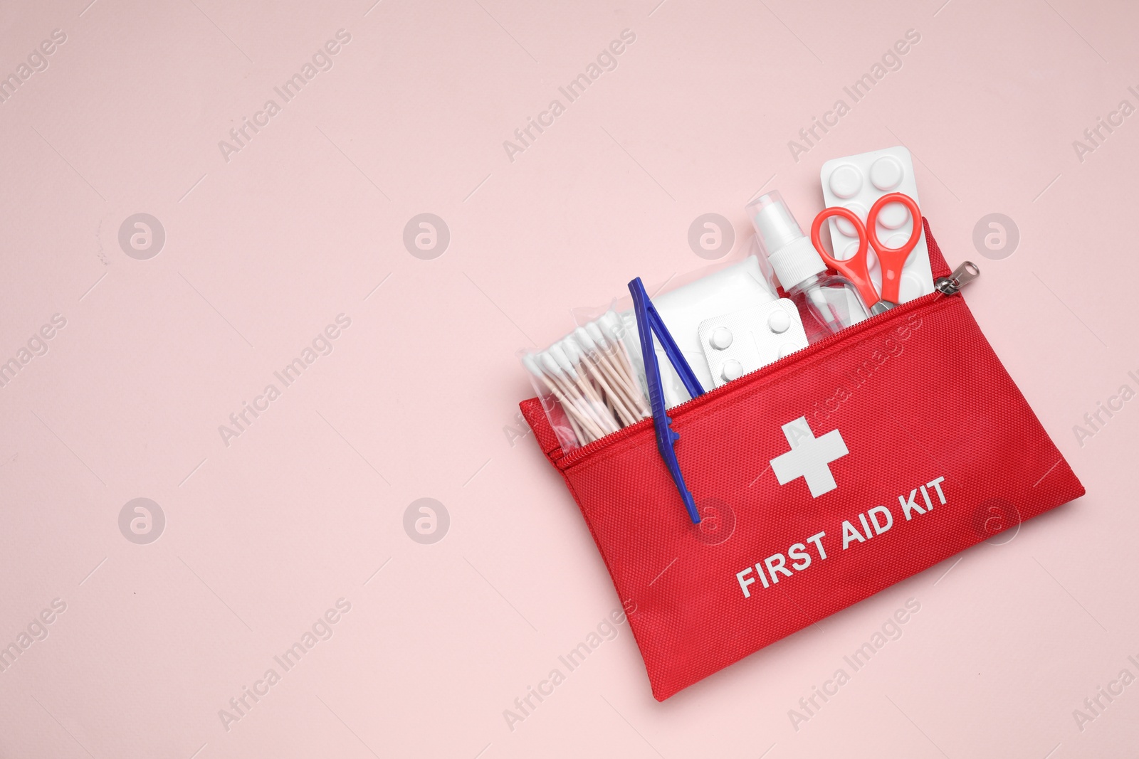 Photo of First aid kit on pink background, top view. Space for text