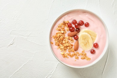 Photo of Bowl with delicious yogurt and granola on table
