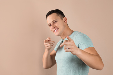 Confident handsome young man on beige background