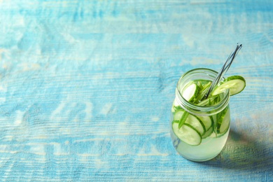 Photo of Natural lemonade with cucumber in jar on wooden table