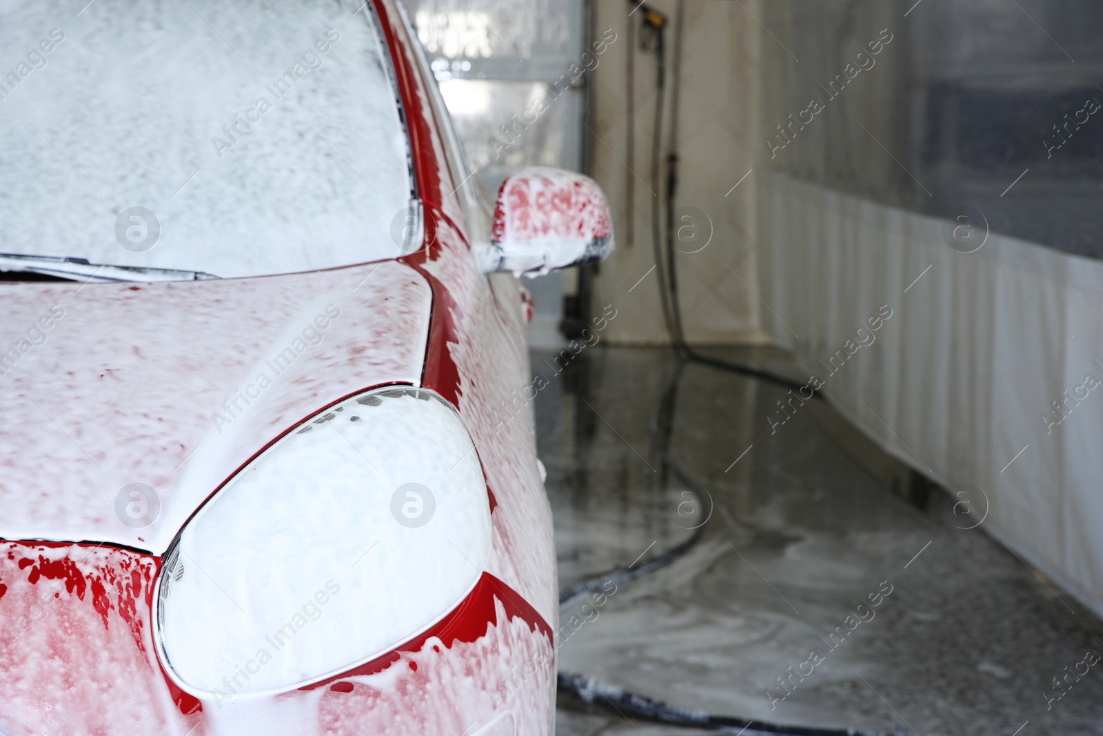 Photo of Auto covered with foam at car wash, space for text. Cleaning service