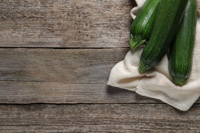 Photo of Raw ripe zucchinis on wooden table, flat lay. Space for text