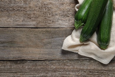 Raw ripe zucchinis on wooden table, flat lay. Space for text