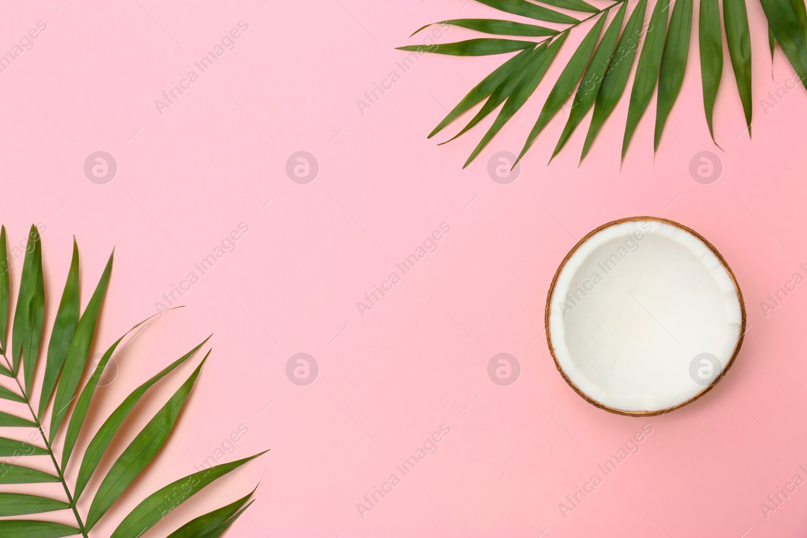 Photo of Fresh coconut and palm leaves on pink background, flat lay. Space for text