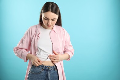 Diabetes. Woman making insulin injection into her belly on light blue background, space for text