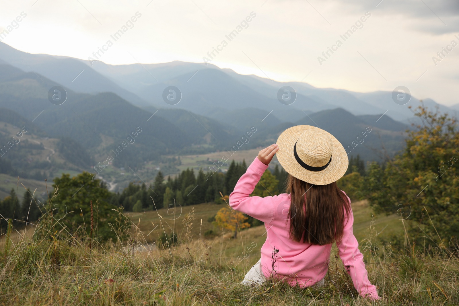 Photo of Young woman enjoying beautiful mountains landscape, back view. Space for text