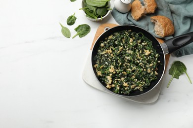 Photo of Tasty spinach dip with eggs in dish served on white table, flat lay. Space for text