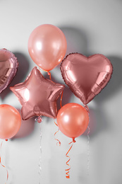 Photo of Different balloons near light wall. Festive decor