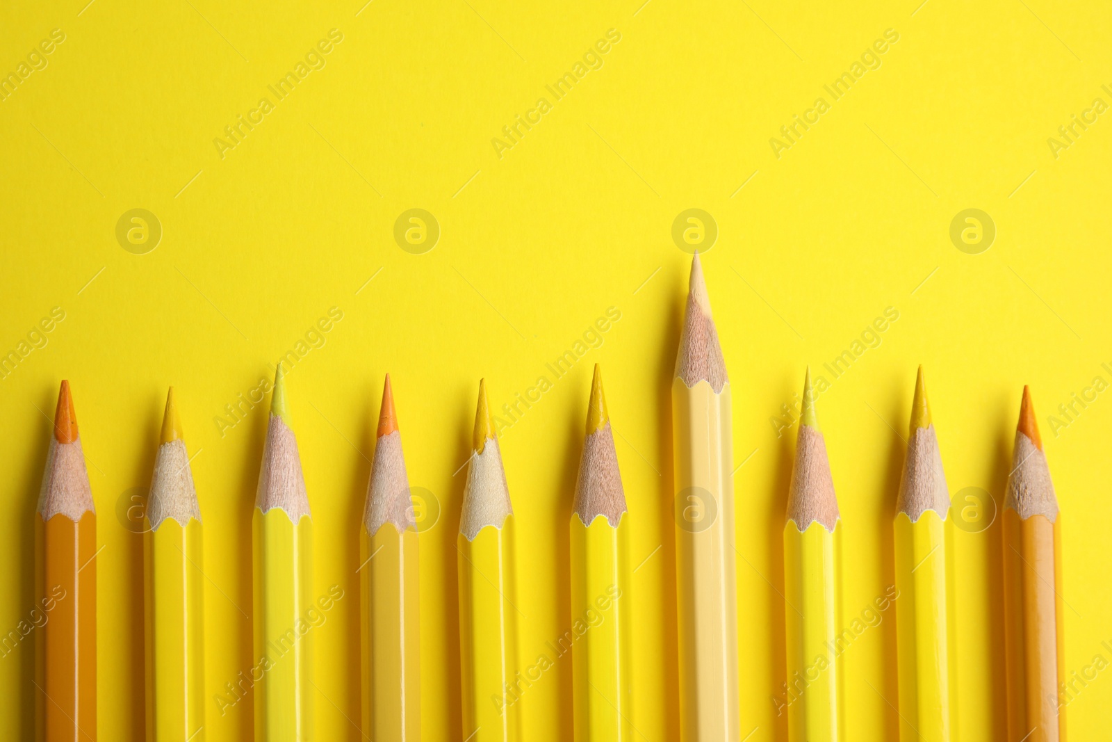 Photo of Flat lay composition with color pencils on yellow background