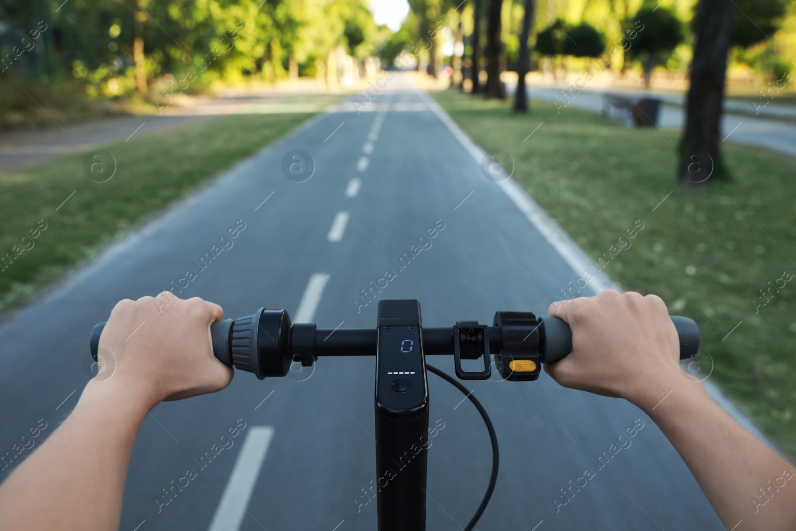 Photo of Woman riding modern electric kick scooter in park, closeup