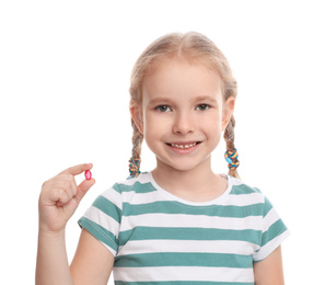 Photo of Little girl with vitamin pill on white background
