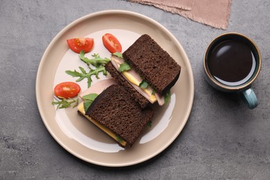Photo of Delicious sandwiches with boiled sausage, tomato, cheese and arugula on grey table, flat lay