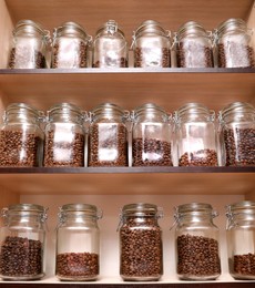 Photo of Glass jars with coffee beans on rack