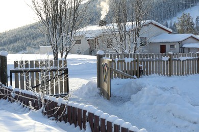 Photo of Beautiful view of house, snowy trees and bushes outdoors. Winter landscape