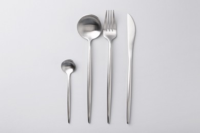 Photo of Stylish cutlery set on grey table, flat lay