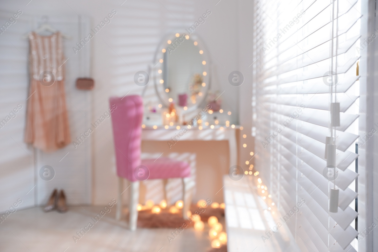 Photo of Blurred view of stylish room with dressing table and pink chair