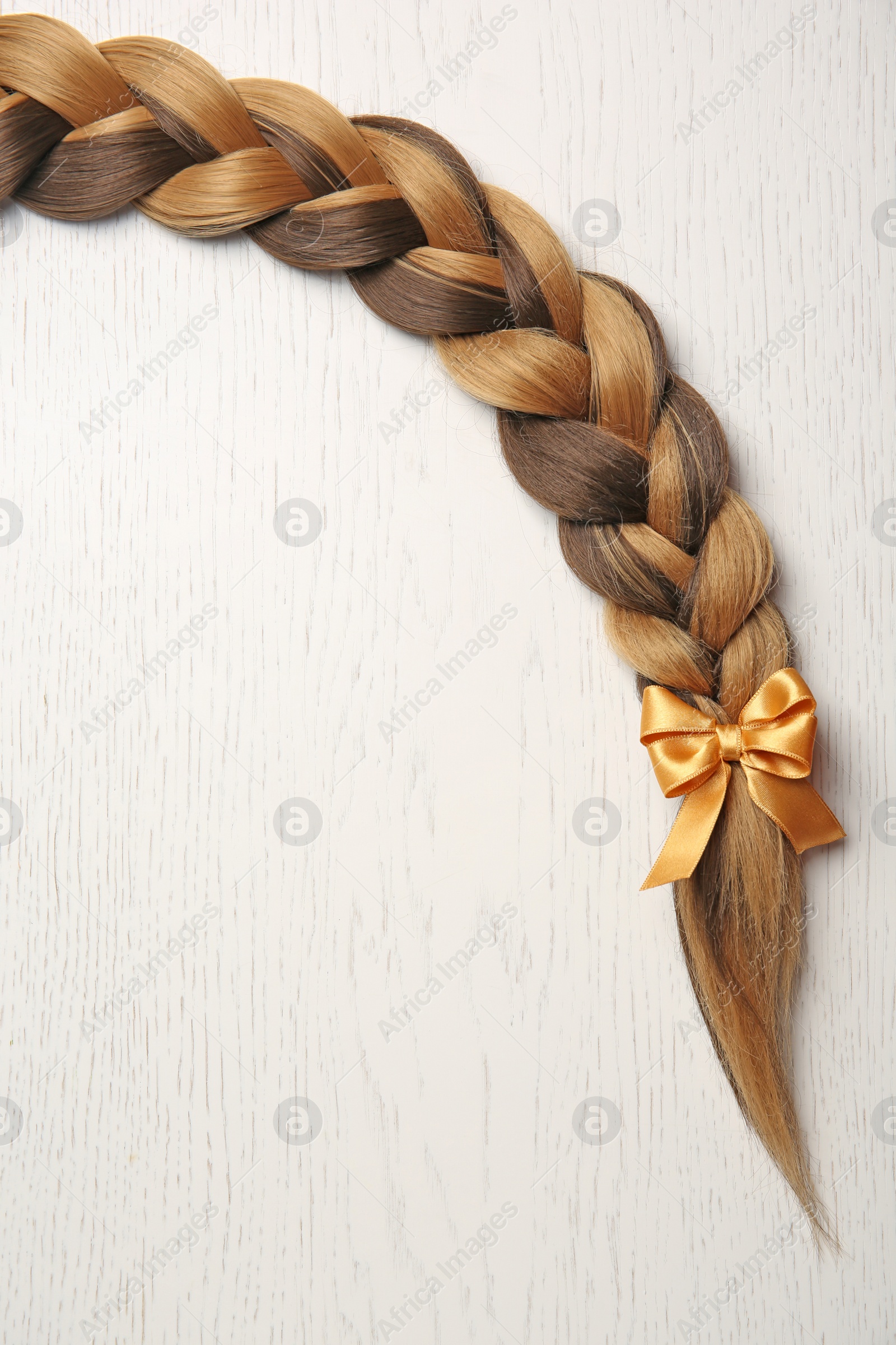 Photo of Braid and space for text on light background, top view. Healthy hair