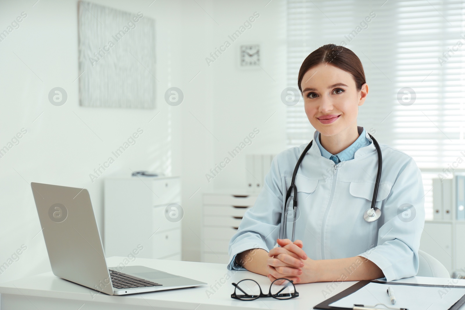 Photo of Portrait of young female doctor in white coat at workplace