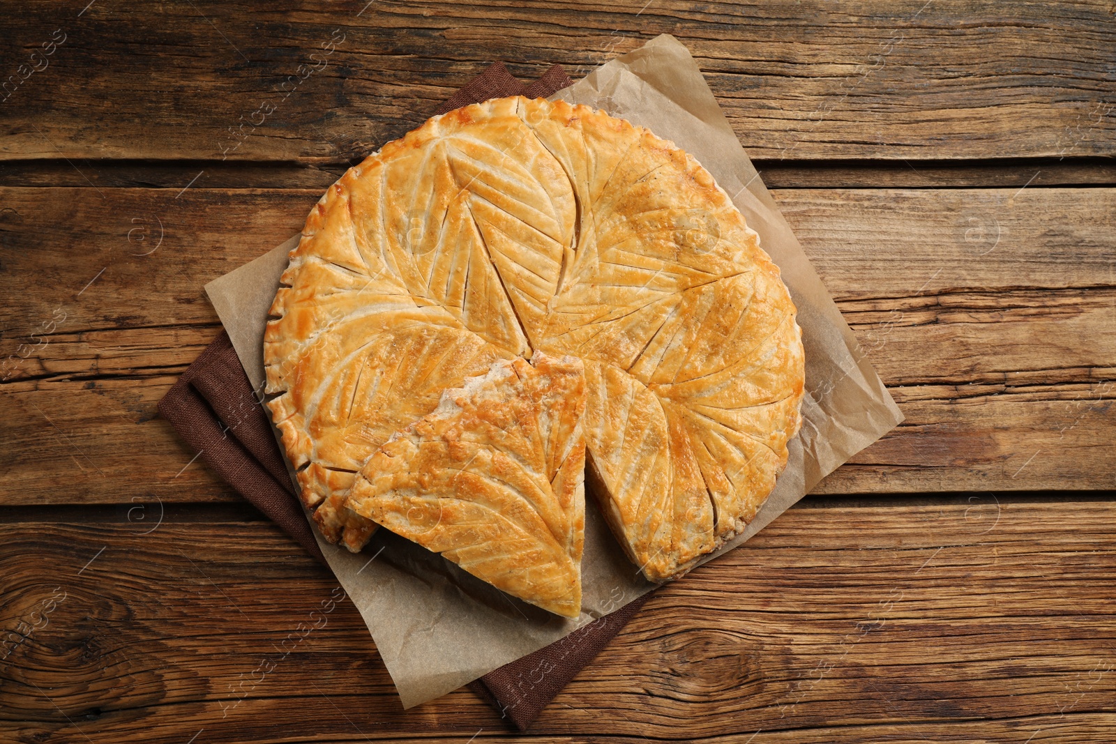 Photo of Traditional galette des Rois on wooden table, above view. Space for text