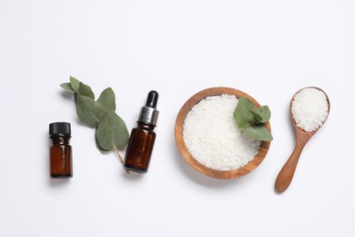 Aromatherapy products. Bottles of essential oil, sea salt and eucalyptus leaves on white background, flat lay