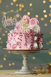 Photo of Beautiful birthday cake with festive decor and candle on white table
