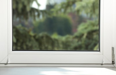 Empty wooden window sill and spruce trees outside