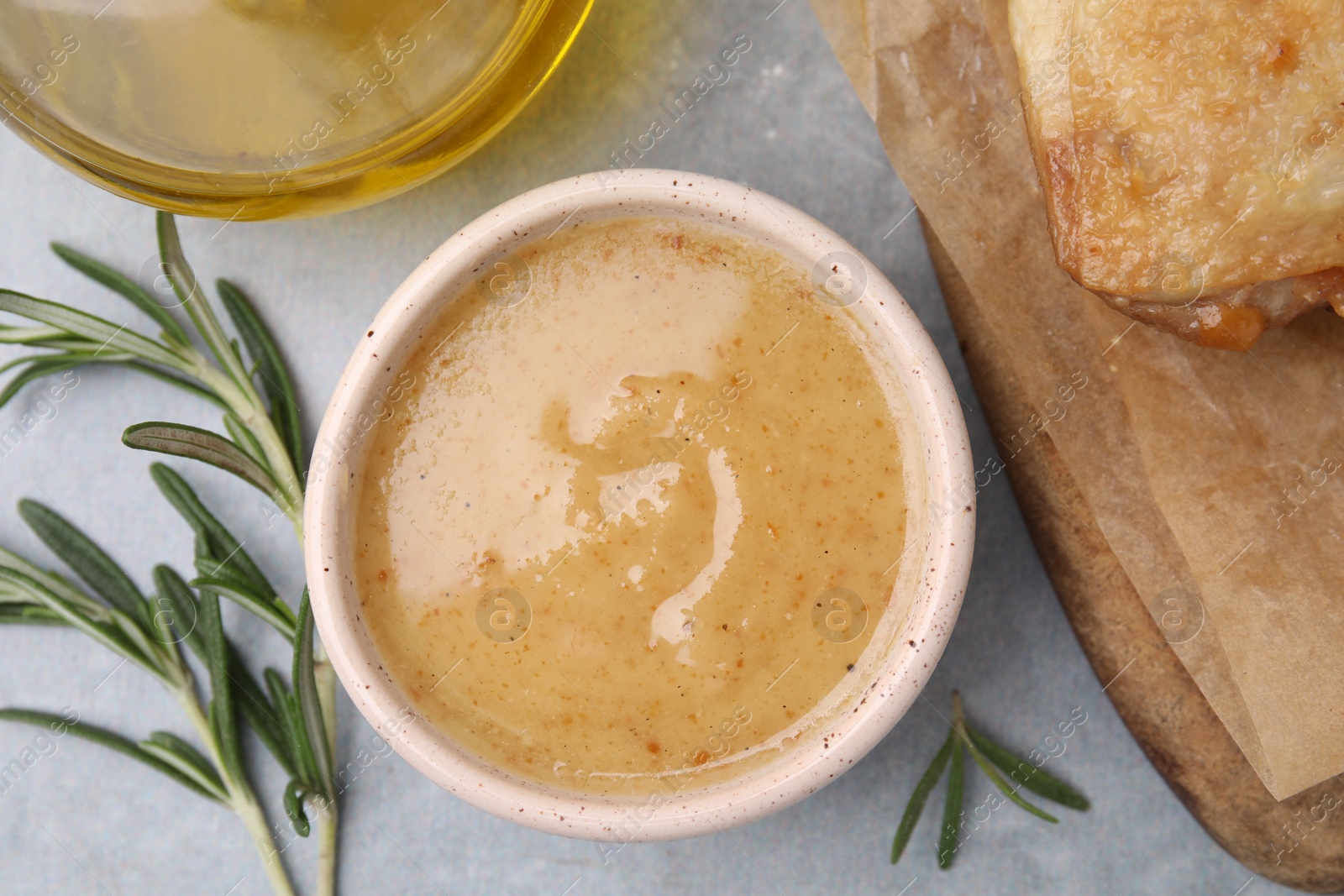 Photo of Delicious turkey gravy and rosemary on grey table, top view