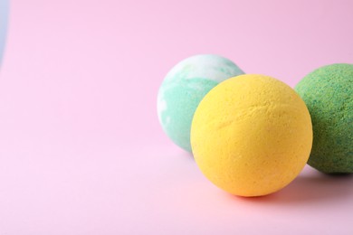 Photo of Colorful bath bombs on pink background, closeup. Space for text