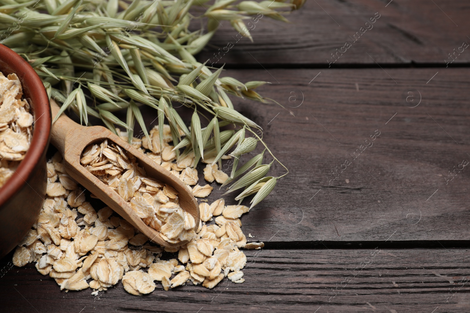 Photo of Oatmeal and branches with florets on wooden table. Space for text