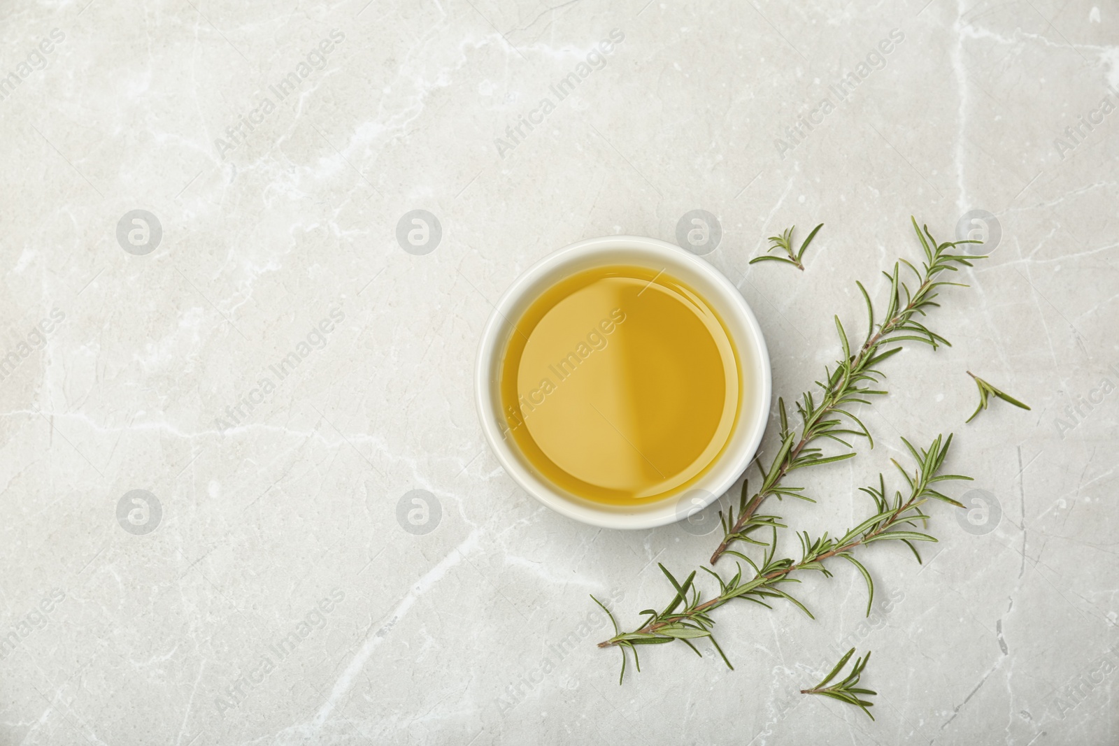 Photo of Flat lay composition with rosemary oil on light background