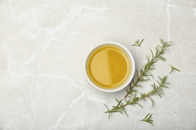 Flat lay composition with rosemary oil on light background