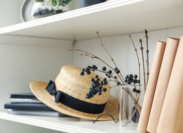 White shelving unit with straw hat and different decorative elements