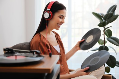 Photo of Woman listening to music with turntable at home