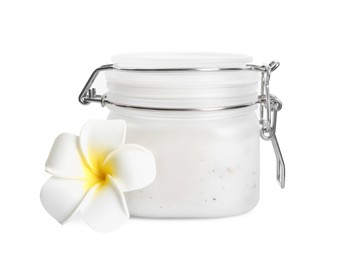 Photo of Jar of exfoliating salt scrub and plumeria flower on white background