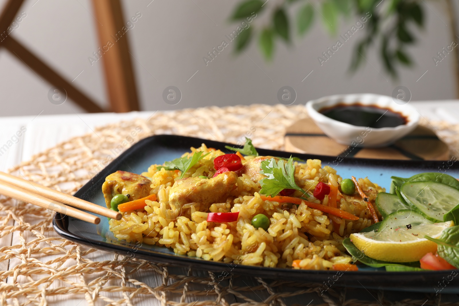 Photo of Tasty rice with meat and vegetables in plate on table, closeup