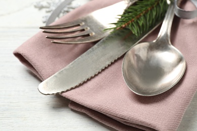 Photo of Cutlery set and festive decor on white wooden table, closeup. Christmas celebration