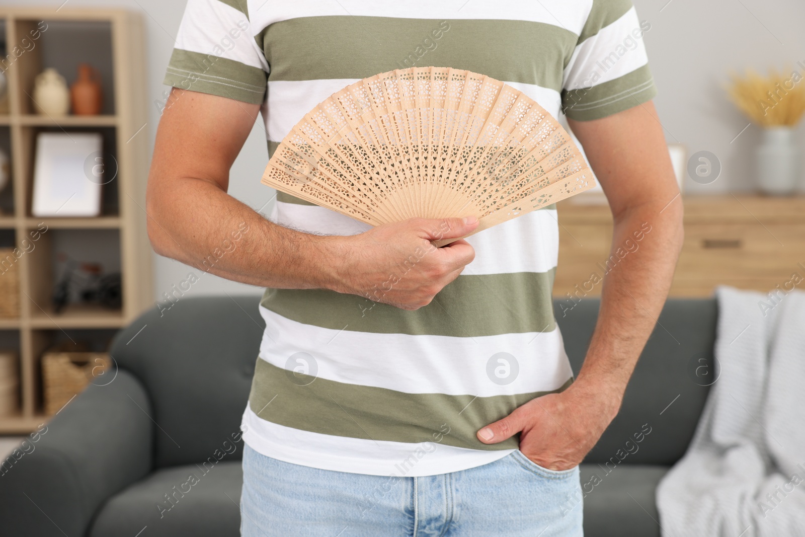 Photo of Man with hand fan at home, closeup
