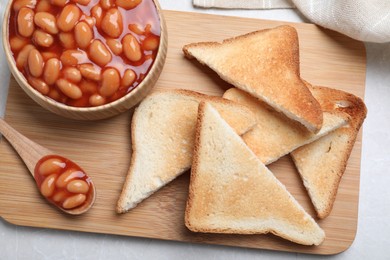 Photo of Toasts and delicious canned beans on white table, top view